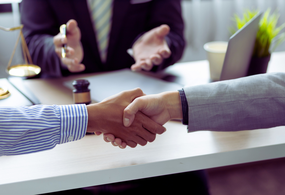 shaking hands across a desk